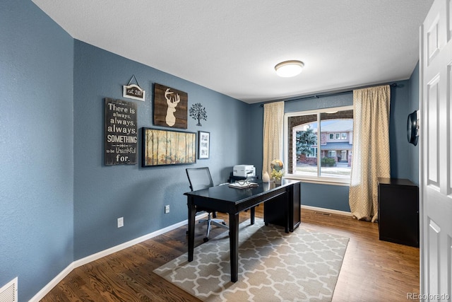 home office with hardwood / wood-style flooring and a textured ceiling