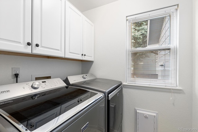 washroom featuring washer and clothes dryer and cabinets