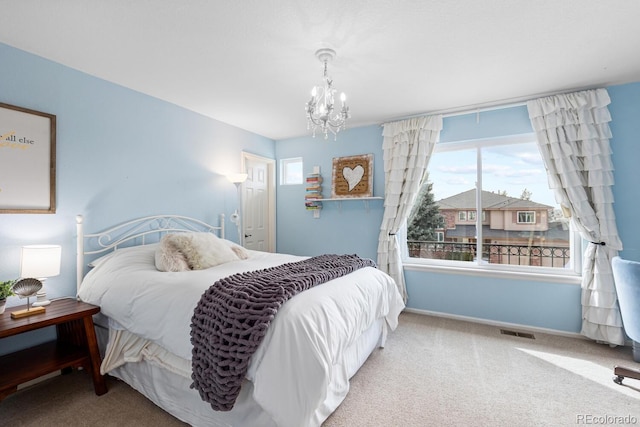 bedroom with carpet flooring and a notable chandelier