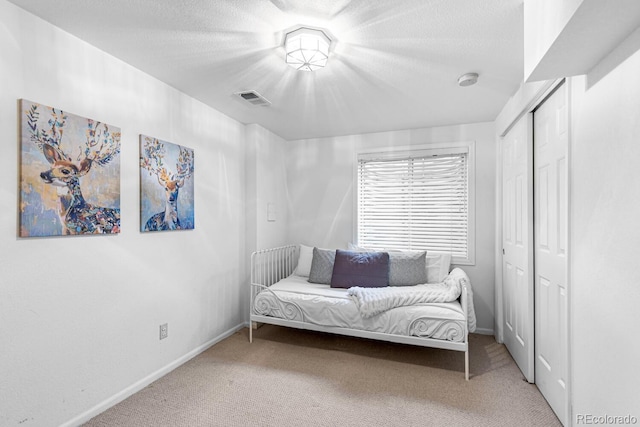 sitting room with light carpet and a textured ceiling