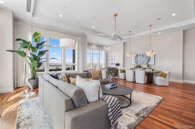 living room with a healthy amount of sunlight, wood finished floors, and a ceiling fan