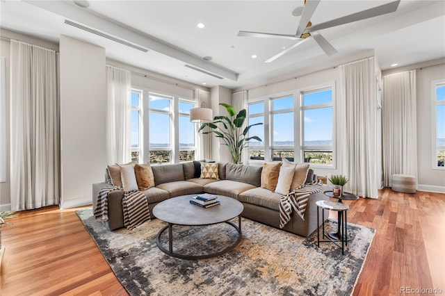 living room with light wood-type flooring, a healthy amount of sunlight, and ceiling fan