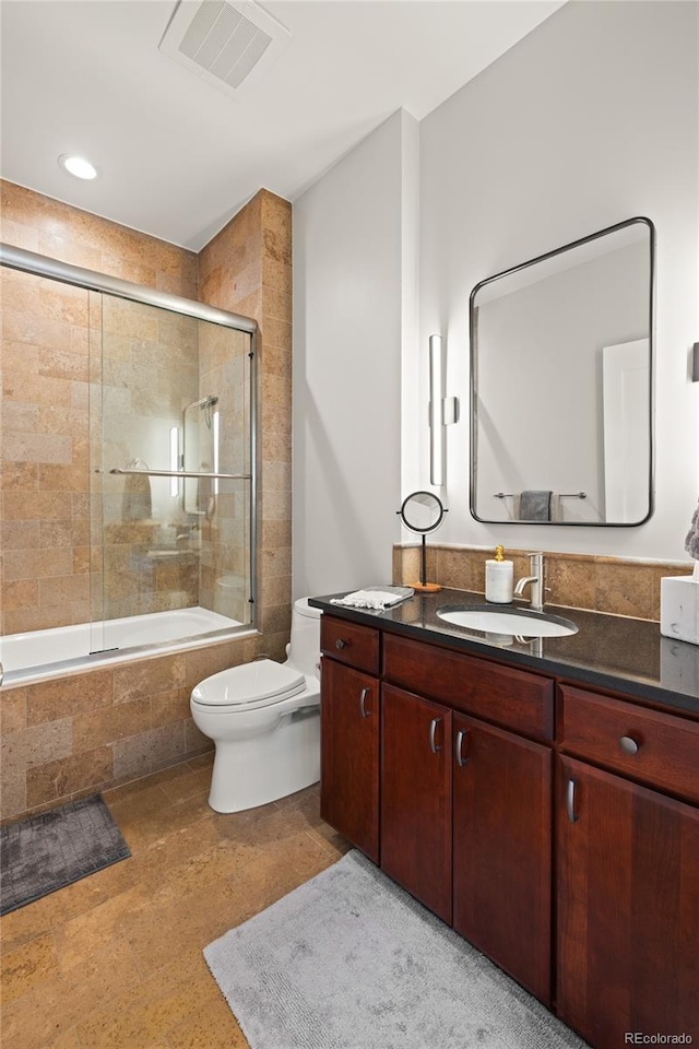 full bath with toilet, tiled shower / bath, vanity, and visible vents