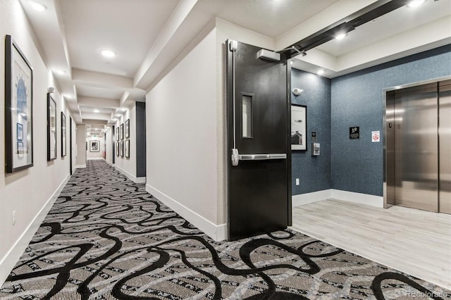 hall with hardwood / wood-style floors and elevator