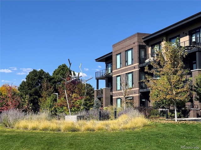 exterior space featuring a lawn and a balcony