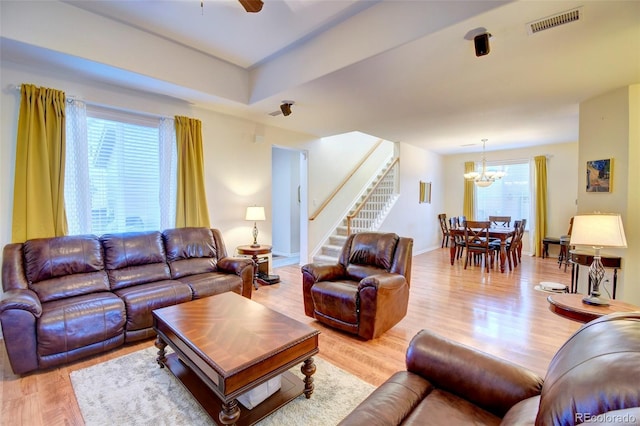 10550 Ashfield St, Highlands Ranch, CO 80126 - living room with stairs, light wood-style floors, a chandelier, and ceiling fan