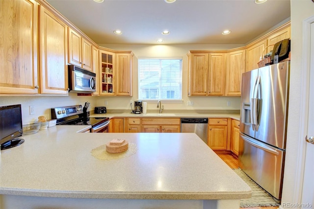 10550 Ashfield St, Highlands Ranch, CO 80126 - kitchen featuring appliances with stainless steel finishes, light brown cabinets, a peninsula, recessed lighting, and light countertops