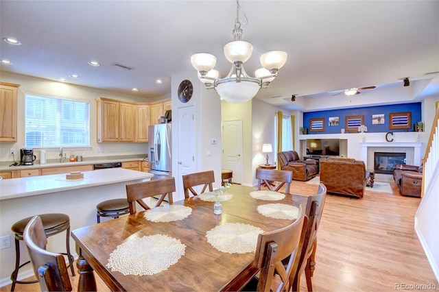 10550 Ashfield St, Highlands Ranch, CO 80126 - dining space featuring recessed lighting, a glass covered fireplace, light wood finished floors, ceiling fan, and a chandelier