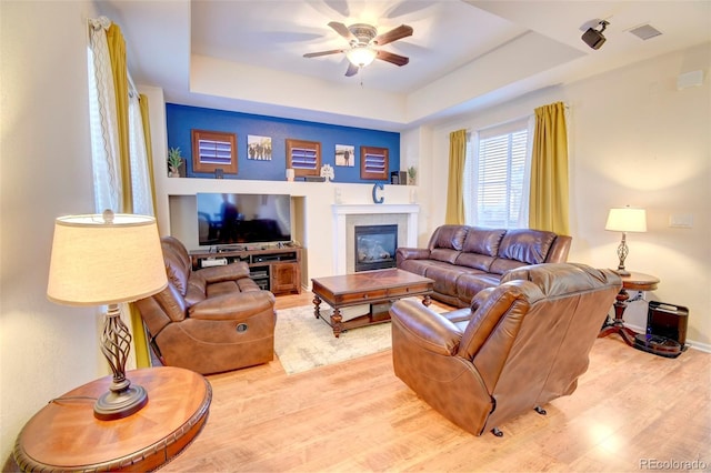 10550 Ashfield St, Highlands Ranch, CO 80126 - living area with wood finished floors, a ceiling fan, and a raised ceiling
