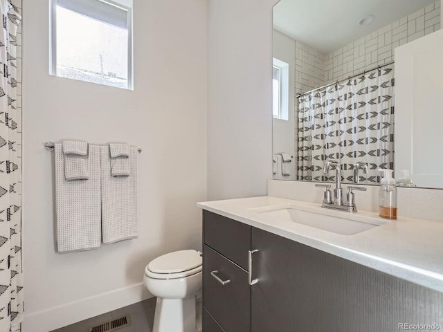 bathroom with tile patterned floors, vanity, toilet, and plenty of natural light