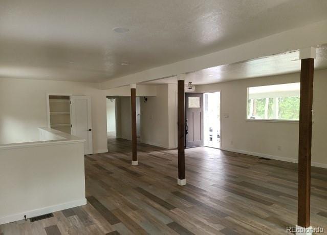 basement with baseboards and dark wood-type flooring