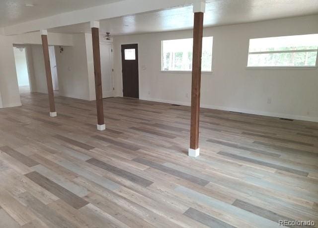 basement featuring light wood-type flooring and baseboards