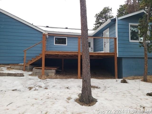 snow covered property featuring stairs