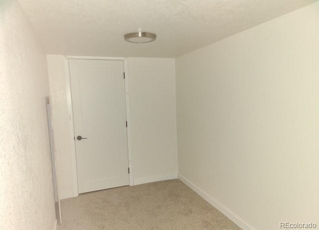 empty room with baseboards and light carpet