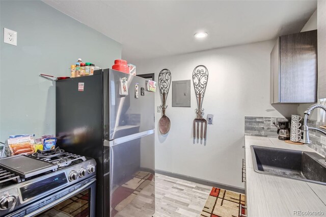 3081 W 18th Ave, Denver, CO 80204 - kitchen with stainless steel appliances, electric panel, light wood-style floors, light countertops, and tasteful backsplash