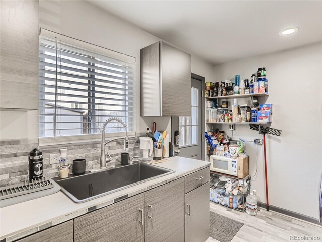 3081 W 18th Ave, Denver, CO 80204 - kitchen featuring light countertops, light wood-style flooring, backsplash, white microwave, and recessed lighting