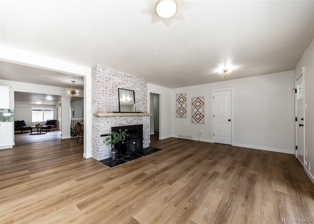 735 Valley Rd, Colorado Springs, CO 80904 - unfurnished living room with light wood-style flooring, baseboards, and a brick fireplace