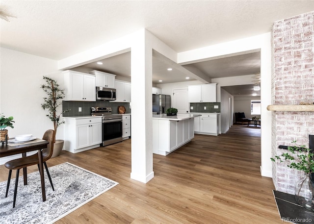 735 Valley Rd, Colorado Springs, CO 80904 - kitchen featuring stainless steel appliances, tasteful backsplash, light countertops, white cabinets, and light wood-type flooring