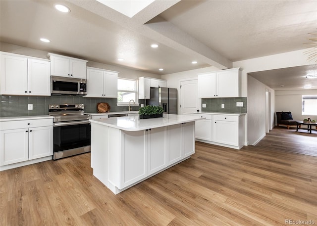 735 Valley Rd, Colorado Springs, CO 80904 - kitchen with stainless steel appliances, light wood-type flooring, decorative backsplash, a center island, and recessed lighting