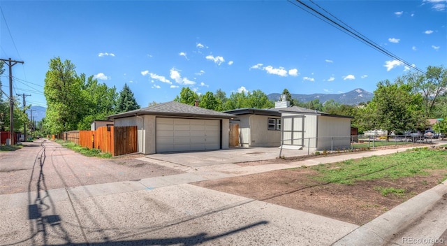 735 Valley Rd, Colorado Springs, CO 80904 - view of front facade with a gate, concrete driveway, and a mountain view
