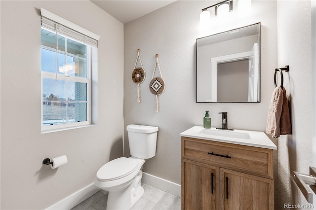 bathroom featuring vanity, toilet, and baseboards