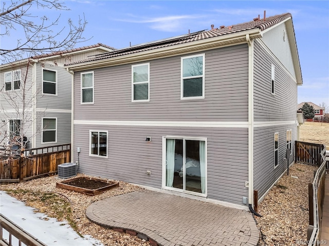 rear view of property with a patio, central AC unit, fence, and a vegetable garden