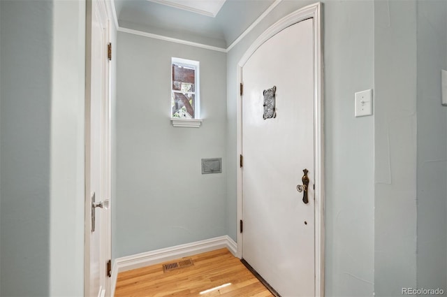 doorway to outside featuring light wood finished floors, baseboards, and ornamental molding