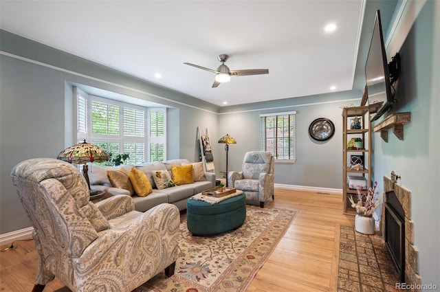 living room with light wood-type flooring, baseboards, ceiling fan, and recessed lighting