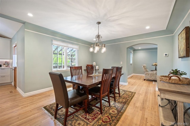 dining room featuring arched walkways, light wood-style floors, baseboards, recessed lighting, and a chandelier