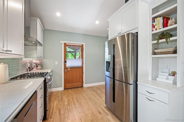 kitchen featuring stainless steel appliances, white cabinets, light wood-style flooring, baseboards, and recessed lighting