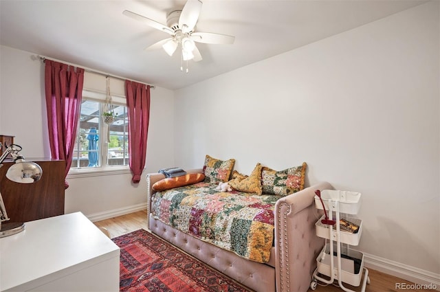 bedroom with baseboards, light wood-type flooring, and ceiling fan
