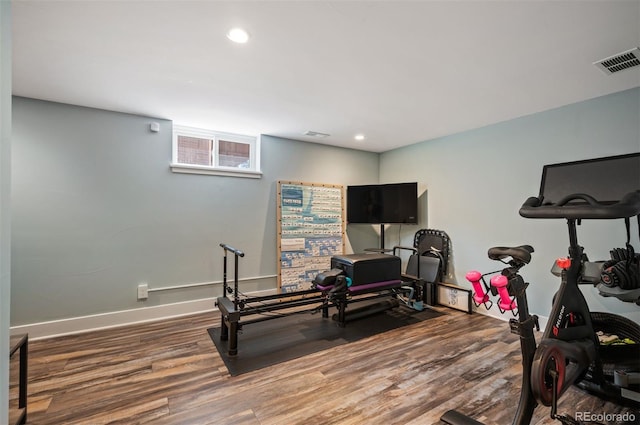 exercise room featuring wood finished floors, recessed lighting, and baseboards
