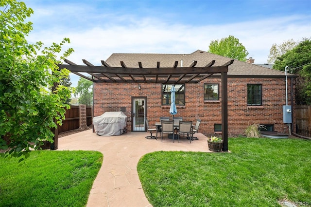 back of house with brick siding, a pergola, a patio area, and roof with shingles