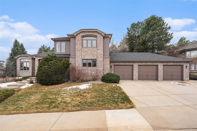 traditional home with a front lawn, concrete driveway, brick siding, and an attached garage