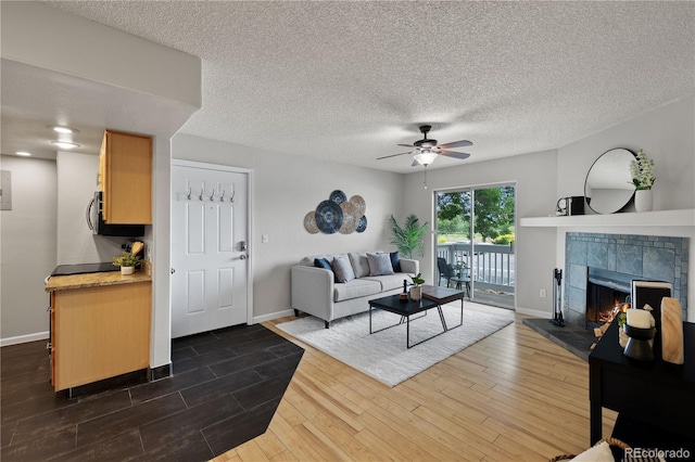 13404 E Jewell Ave Unit 101, Aurora, CO 80012 - living room featuring ceiling fan, dark wood finished floors, a tiled fireplace, a textured ceiling, and electric panel