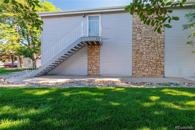 13404 E Jewell Ave Unit 101, Aurora, CO 80012 - rear view of property featuring a yard and stairway