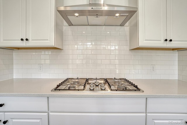 17396 Hop Clover Ave, Parker, CO 80134 - kitchen featuring exhaust hood, stainless steel gas stovetop, white cabinetry, and backsplash