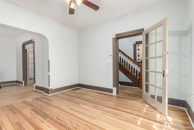 unfurnished room featuring french doors, light hardwood / wood-style flooring, and ceiling fan