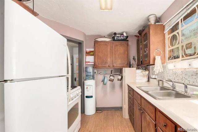 kitchen featuring decorative backsplash, sink, and white appliances