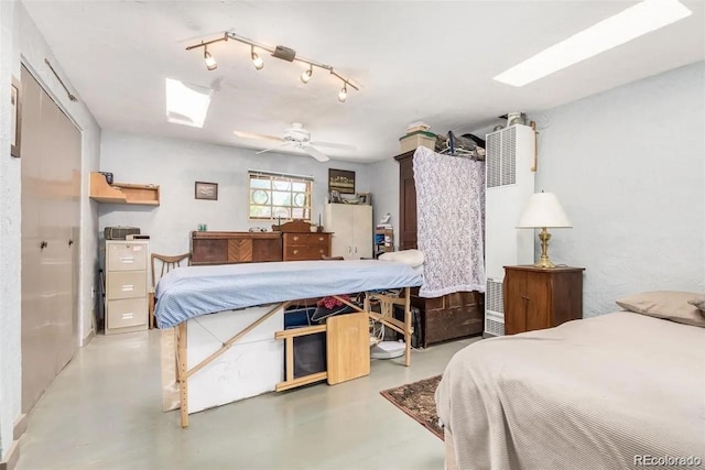 bedroom featuring ceiling fan, concrete flooring, and a skylight