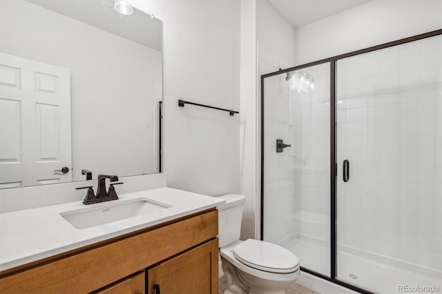 bathroom with vanity, toilet, and a shower with door