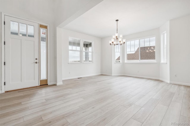 entrance foyer with light hardwood / wood-style floors and a notable chandelier