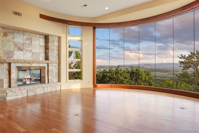 606 Cliffgate Ln, Castle Rock, CO 80108 - unfurnished living room featuring wood finished floors, a stone fireplace, and recessed lighting