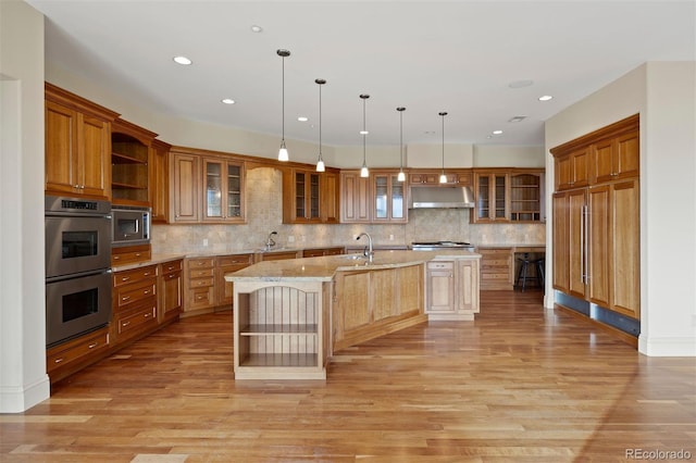 606 Cliffgate Ln, Castle Rock, CO 80108 - kitchen featuring open shelves, appliances with stainless steel finishes, under cabinet range hood, an island with sink, and recessed lighting