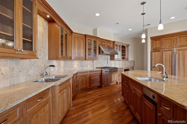606 Cliffgate Ln, Castle Rock, CO 80108 - kitchen with dark wood finished floors, stainless steel gas cooktop, under cabinet range hood, tasteful backsplash, and hanging light fixtures
