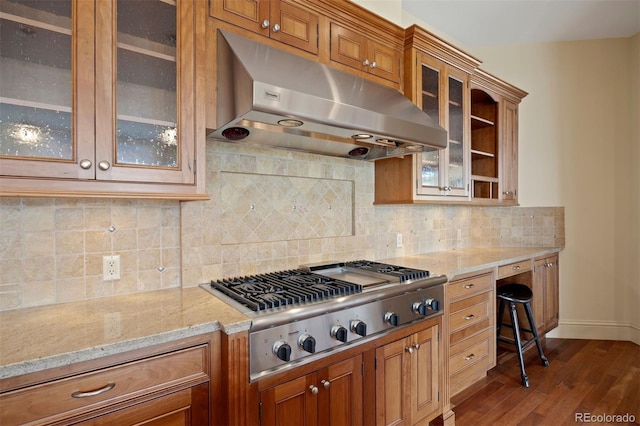 606 Cliffgate Ln, Castle Rock, CO 80108 - kitchen featuring under cabinet range hood, stainless steel gas cooktop, dark wood-type flooring, and brown cabinetry