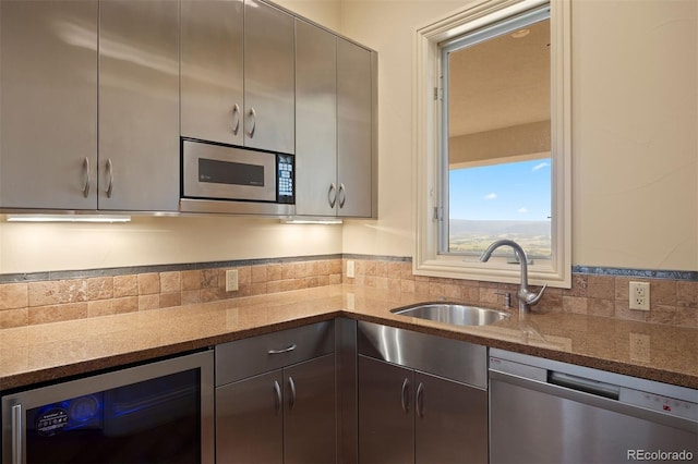 606 Cliffgate Ln, Castle Rock, CO 80108 - kitchen featuring appliances with stainless steel finishes, beverage cooler, stone counters, gray cabinetry, and decorative backsplash