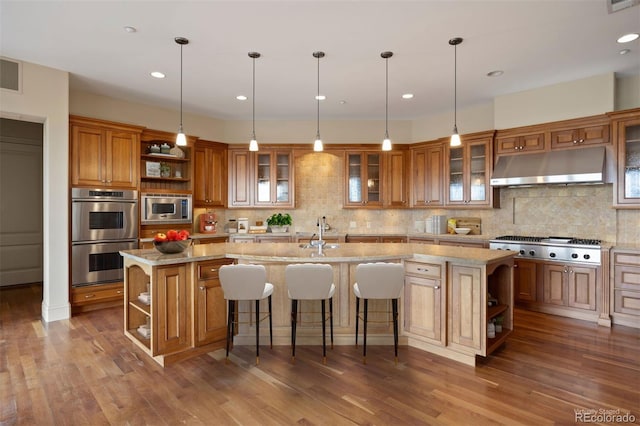 606 Cliffgate Ln, Castle Rock, CO 80108 - kitchen featuring open shelves, under cabinet range hood, stainless steel appliances, brown cabinets, and a large island