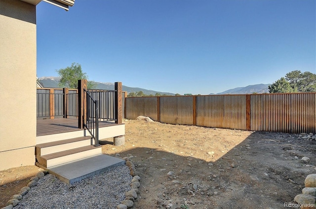 view of yard with a deck with mountain view