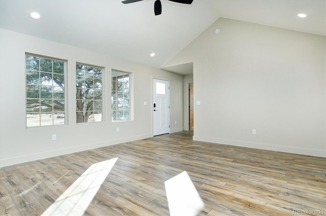 spare room with light hardwood / wood-style flooring, ceiling fan, and high vaulted ceiling